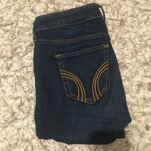 Hollister - Hollister jeans, storlek W26 och L28. Köpta i Täby Centrum och använda max 3 gånger. Grymt snygga på!! Inga defekter/skador. Passar S och någon som är mellan 155-165 cm lång. LÅGMIDJADE. Nypriset är 500 kr