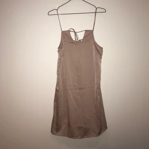 Sidenklänning - Ljusrosa klänning i sidenliknande material. Jättefin knytning i ryggen, aldrig använd.