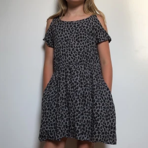 Grå leopard klänning - Har sällan används och funkar perfekt som en fest klänning👍🏻 Klänningen har hål i axlarna och även ett litet vid nacken.