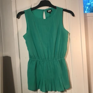 Grön topp  - Snygg grön topp med lite volang nertill. Är lite mer klarare grön än vad bilden visar. Från Bikbok. 50kr + frakt 