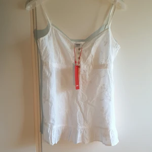 Nytt linne  - Nytt vitt linne med brodyr och liten volang längs ner. Lappar sitter kvar. Köparen står för frakten 