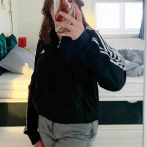  - En Adidaskofta med fickor och ett ”mönster” på magen