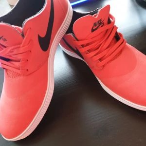 Nikeskor - Snygga röda nikeskor, storlek 9/42.5 (herr-modell) Sparsamt använda och i gott skick! Frakt tillkommer! 