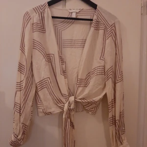  - Oanvänt knytblus från HM. Stl 42. Finns i Västerås eller skickas mot frakt.