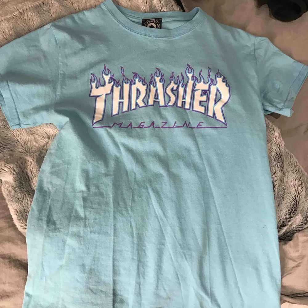 Ljusblå thrasher T-shirt med lila flammor. Mycket bra skick knappt använd . T-shirts.