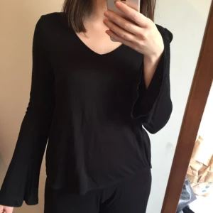  - Svart topp med breda ärmar. 