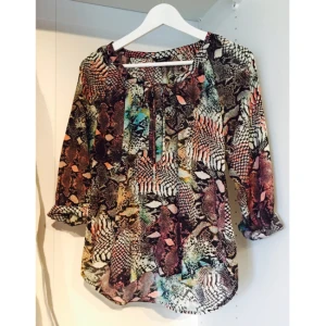  - Långärmad blus med mönster från Lindex storlek XS. Endast använd ett fåtal gånger. Väldigt tunn och skön på sommaren. Ej genomskinligt tack vare mönstret. Knyt upptill. 