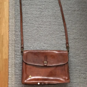  - Handväska i lackat skinn! Har tre fack inuti :) 