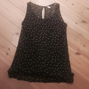  - Genomskinlig, svart, prickig top från only i storlek 34.