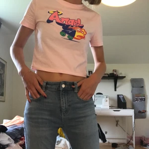 Croppad t-shirt - En lite kortare ljusrosa t - shirt med tryck. Kommer inte ihåg vad jag köpte den för men eftersom den aldrig är använd säljer jag den för 70kr + frakt. Kan annars även mötas upp i Stockholm :)