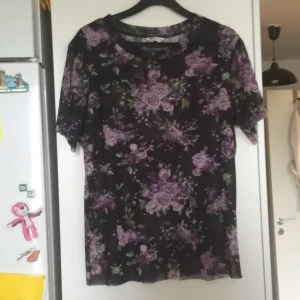 Svartblommig meshtshirt stl s - Mesh topp med lila blommor på. Stor i storleken.