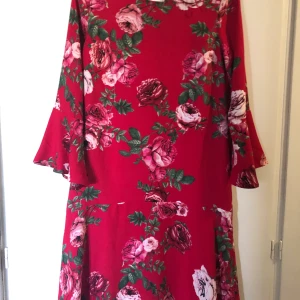 Röd Klänning - Superfin röd och blommig klänning från Kappahl, oanvänd. Storlek M