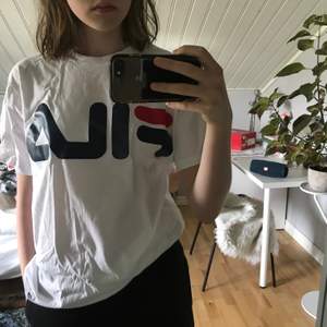 Supersnygg FILA T-shirt men säljer pågrund av att den inte kommit till användning! Trycket på vänstra armen är bara lite ”utsuddat” av att jag har råkat strykit på det, men det är ytterst lite och syns nästan inte!