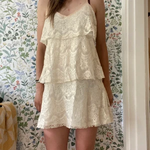 Valerie klänning - En vit och guldglänsande klänning i 3 etapper. Luftig passform, något kort för oss längre. Jag är 179cm, hade klänningen endast en gång på min student 2012. Därav är skicket super. Nypris var ca 2500kr.