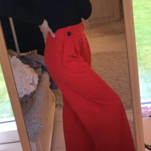 vida byxor, tajt midja - säljer dessa röda byxor som sitter tajtare i midjan och kring rumpan men blir vida längst benen. fin detalj som liknar ett bälte, skriv till mig vid frågor! 😊