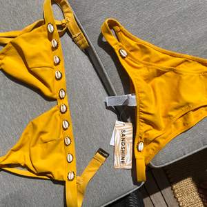 Jätte snygg gul bikini med snäck-detaljer, köpt i costa rica och alldrig använd! Frakt tillkommer