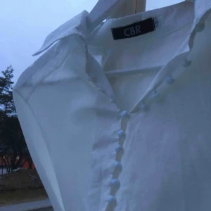  - Fin vit skjorta med ballongärmar och unika knappar! Jättesnygg oversized! Helt nyskick, inte alls använd. Skriv för bättre bilder eller frågor :) 