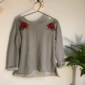  - Grå tröja med broderade rosor