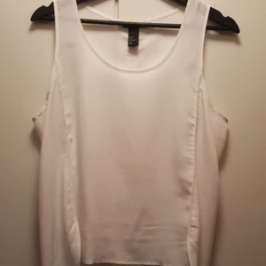  - Vitt linne, urringat, kortare framtill och längre baktill.