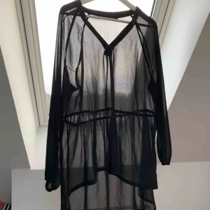  - Strand kaftan med glitterdetalj, säljer pågrund av för stor storlek. Använd 2 gånger. Fraktar om köparen står för frakt, kan mötas upp.