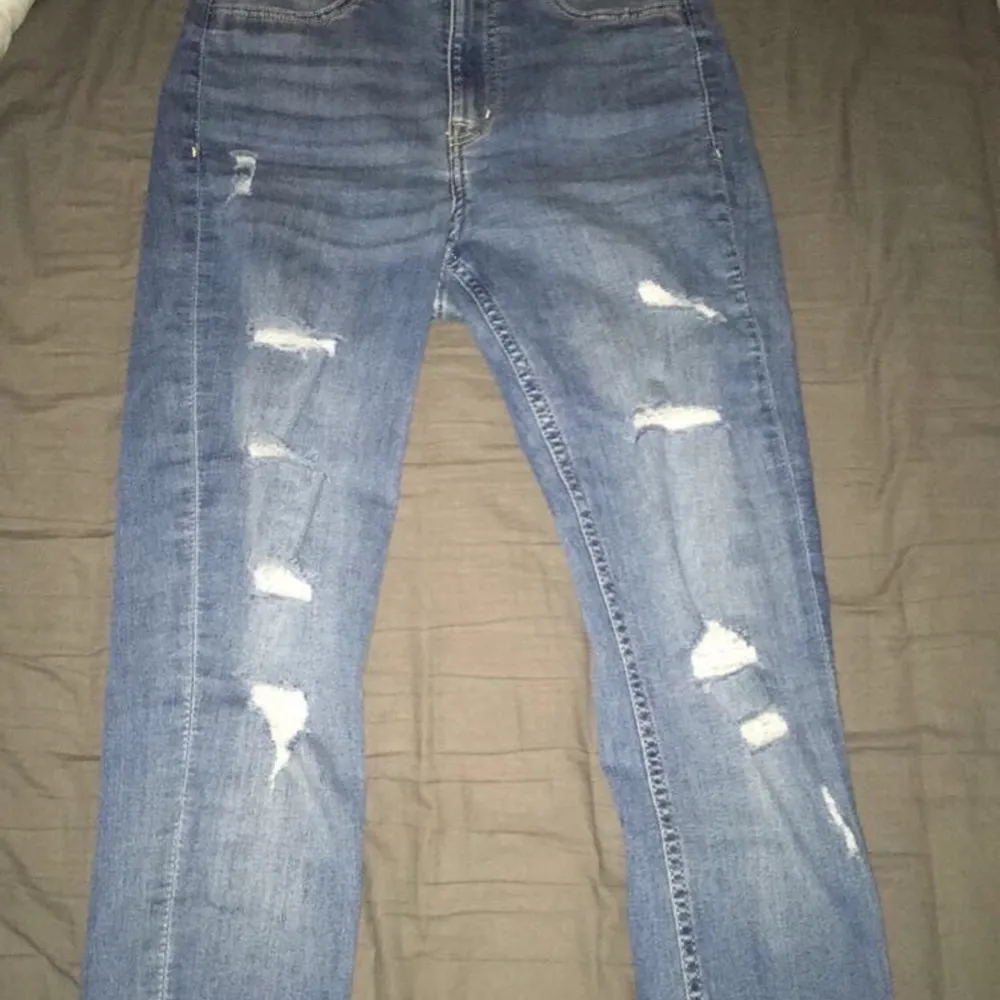 Blåa skinny jeans med hål från HM. Byxorna sitter bra på mig, är omkring 1,60m lång. Men säljer för att byxorna inte kommer till användning.. Jeans & Byxor.