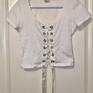 Vit croppad topp - En söt vit croppad topp med snören. Vädkigt enkel och fin att ha med jeans osv. Storlek xs 