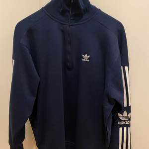 En adidas half zip hoodie i marinblå, endast använd en gång, säljer pga att den inte kommer till användning orginal pris 400, säljer för 200