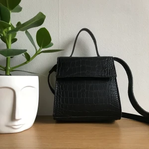 Liten svart väska med orm print  - En söt svart väska som jag använder inte. Är i bra skick. Väskan har jag fått. För fler information skriv bara 🌸