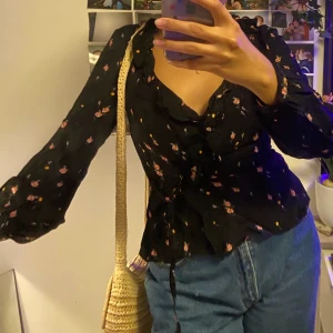Blommig omlott-topp:) - Blommig omlott-topp från H&M ✨ söt som fan men har börjat bli lite liten och kommer tyvärr ej till användning pga det! Svår att fota så om ni är intresserade är det bara att skriva så skickar jag iväg en bättre bild! 🥳