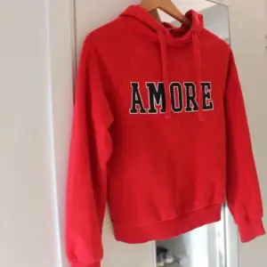 Säljer denna ginatricot hoodie med text ”Amore”. Jättefin röd färg som passar nu till hösten och julen. 