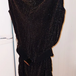 Svart, supersnygg klänning med mesh i ryggen - Stretchigt material och lösare passform upptill och nertill på sidorna är det som rynkad sidosöm och den är mer åtsmitande på "kjoldelen". Strl S, men passar M också. 