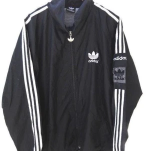 Adidas vind jacka strlk M  - Samma jacka som på bilden förutom luvan. Svart vindjacka från Adidas, nyskick. Använd endast få antal gånger.
