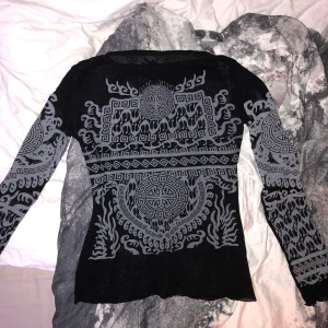 Fräck mönstrad tröja - Långärmad svart tröja med tryck fram i vitt. I lite meshaktigt material. Köpt second hand och är i bra skick! Köparen stor för frakt<3
