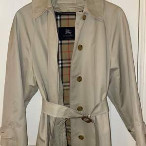 En vintage trench från burberry london. Storlek 10L, vilket är som M. Den är ganska rymlig och skulle passa allt från S-L beroende på hur man vill den ska sitta. Det ingår löstagbart foder och ett bälte. Näst intill nyskick, dm för fler bilder!