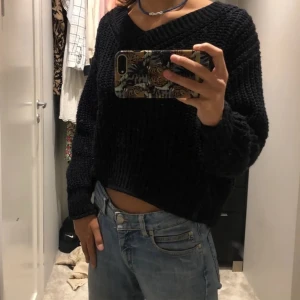 Svart stickad tröja - Jättefin v-ringad stickad tröja, den är relativt kort i modellen och är så snygg till ett par jeans. Går även att ha lite off shoulder om man föredrar det.