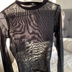 Svart mesh topp  - Långärmad mesh topp i användt skick men inga defekter. Har inget mönster se den andra bilden.  Jätte fin till fest eller ha under något.