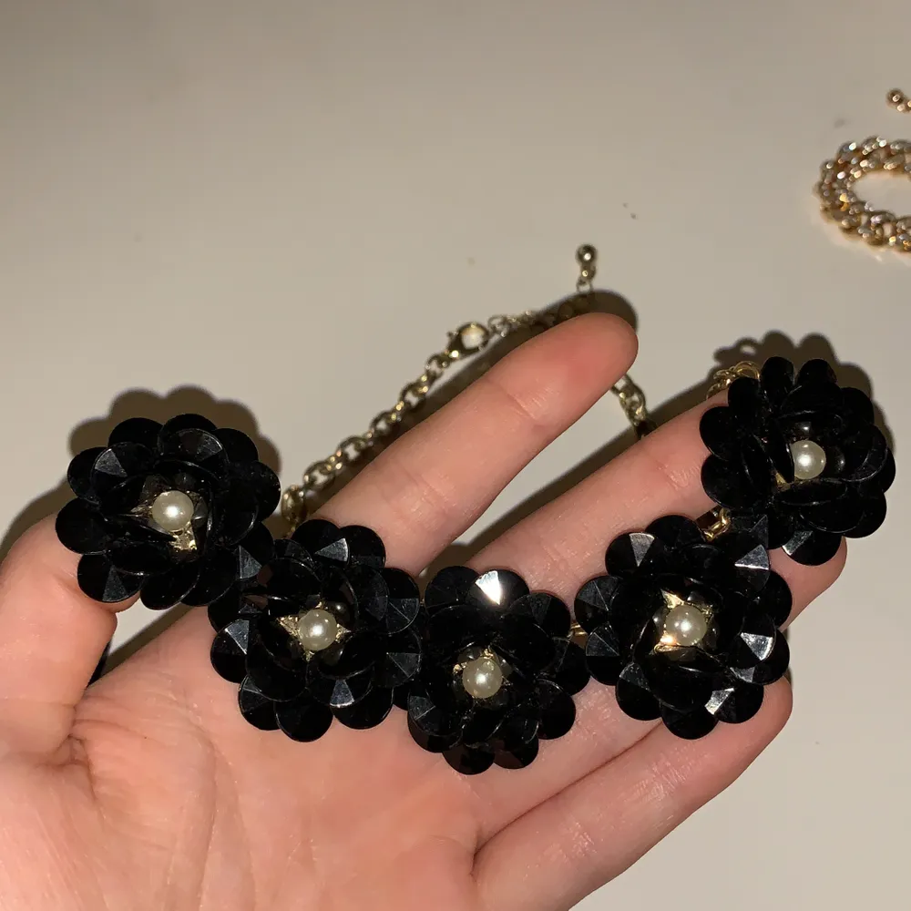 Ett fint halsband i guldfärg och med svarta blommor!. Accessoarer.