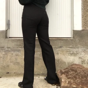 Levi’s - Högmidjade snygga svarta byxor i polyester från Levi’s, gott skick. Köparen står för frakten.