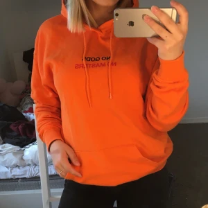 Hoodie  - Trendig orange hoodie med texten ”NO GODS NO MASTERS” på bröstet. Herrmodell men passar lika bra oavsett kön! 