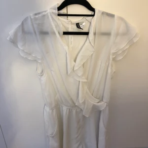Playsuit  - Vit playsuit från h&m Har endast använt en gång på skolavslutningen. Sjukt fint till sommaren. Storlek  L men  passar oxå som M. Kan mötas up i Stockholm eller fraktas men köparen står för frakten.