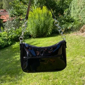Väska - Trendig väska från hm. Glansig på ena sidan och har en söm på andra. Superfint skick! (Allt50kr’s bilder)