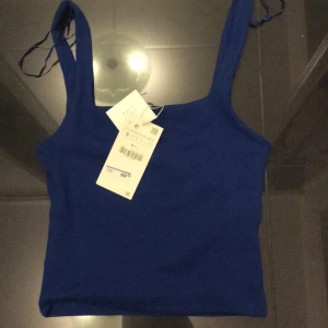 Blå linne - En gullig blå linne med en "inbyggd" topp i. Säljer den pga att axelbanden är för långa på mig. Aldrig använd prislappen är t.o.m kvar! Skit snyggt med bara ett par jeans! 