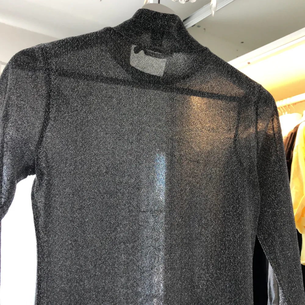 Säljer denna glittriga tröjan från NA-KD, den är väl använd men fortfarande i fint skick. På bild två ser man att den är ganska genom slinkig. Om du är intresserad tveka inte på att skriva till mig☺️. FÖRST TILL KVARN⚠️ KÖPAREN STÅR FÖR FRAKTEN⚠️. Toppar.