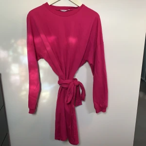 Sweatshirt/klänning från NA-KD - Klänning/sweatshirt från NA-KD i storlek M. Går att använda med eller utan snöre, vilket visas på bild. Använd fåtal gånger så i fint skick. 