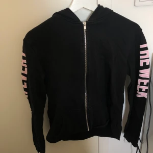 Huvtröja zip från H&M - En svart huvtröja zip från H&M med rosa text längs armarna och på luvan. Väldigt skönt material innanför. Säljes på grund av att den inte passar mig längre. 