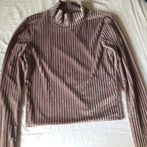Tight high neck tröja - Tajt, väldigt ljust lila färg med guld som tar över tröjan. Säljer pga jag inte använder längre. Använd fåtal gånger. Väldigt fin och passar väldigt bra till svarta jeans🤩 100kr+frakt, pris går att diskutera!🥰