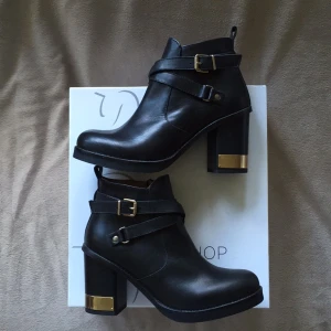  - Snygga läderboots från TOPSHOP i storlek 37. Svarta med guldiga detaljer samt dragkedja. 
Aldrig använda, lappar finns kvar på skorna samt kvitto och originalkartong. Mycket fint skick. 
Köpta i hopp om att kunna använda med en sula då jag själv har storlek 36 men är tyvärr förstora. 
Inköpta 2013 så säljs ej längre i butik/nätet. 
Säljes för 600kr