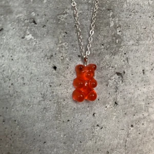 Rött gummibjörnshalsband - Det är 45 cm lågnt         Gummibjön-recin   Kedja-metall    Ej riktig silver 