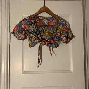 Blommig top - Blommig liten vintage crop top som knyts mellan brösten i tunt fint tyg storlek XS :)