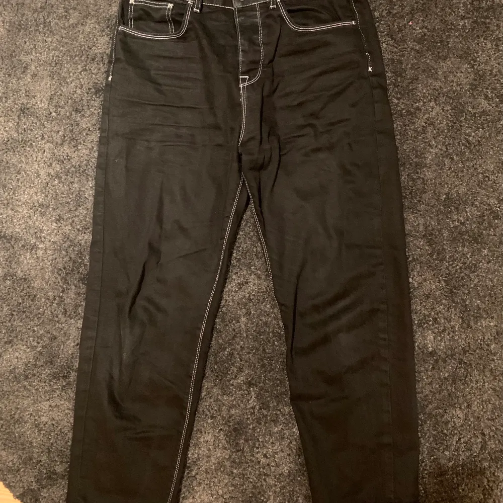 coola svarta jeans med vit kontrastsöm från collusion. storlek 32/32 och ser bäst ut oversized. skriv till mig vid eventuella frågor :). Jeans & Byxor.